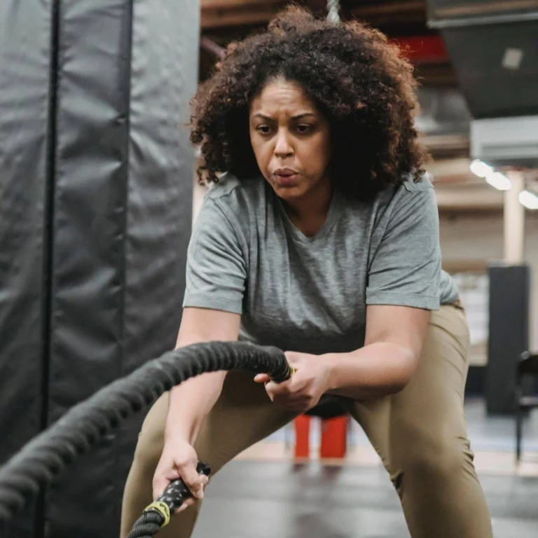 Woman working out with heavy battling ropes