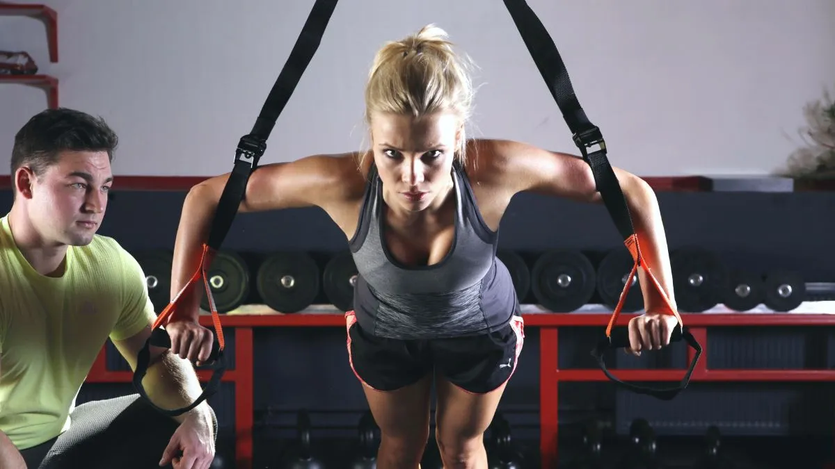 Woman safely exercising upper body with overhead straps