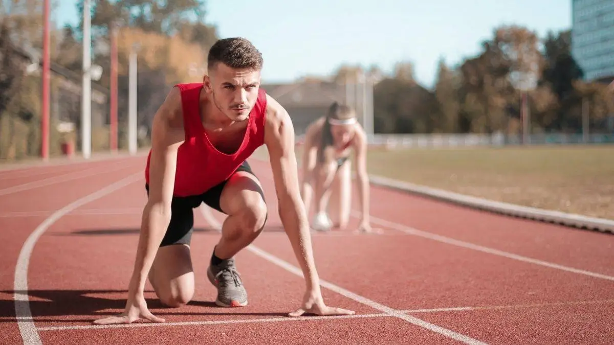 Male track athlete crouched at the starting line