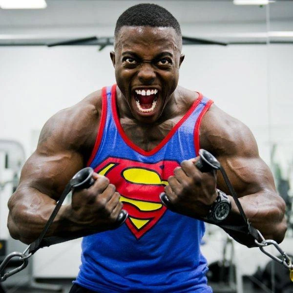 Smiling muscle man flexing with superman shirt