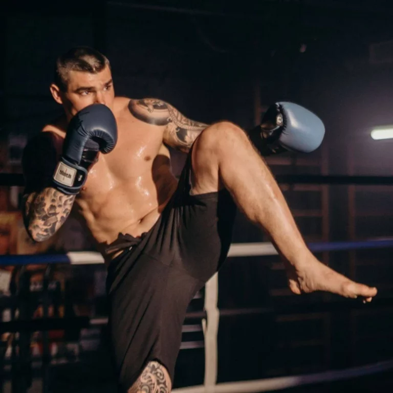 Kickboxing man balancing on one leg in defensive position