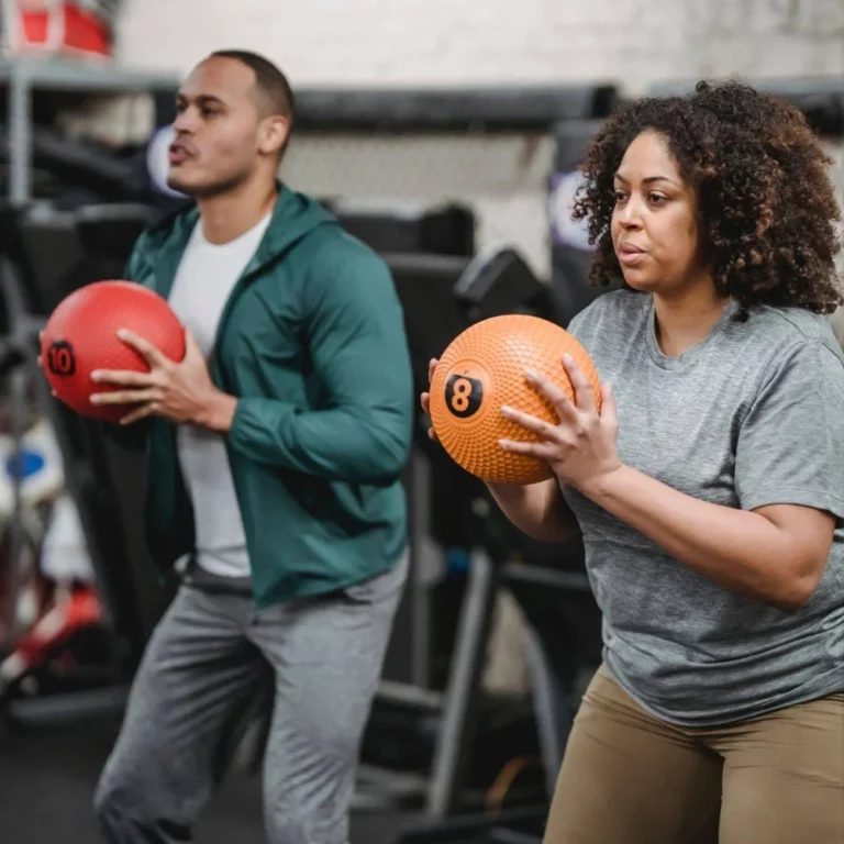 Man and woman fitness training with medicine balls