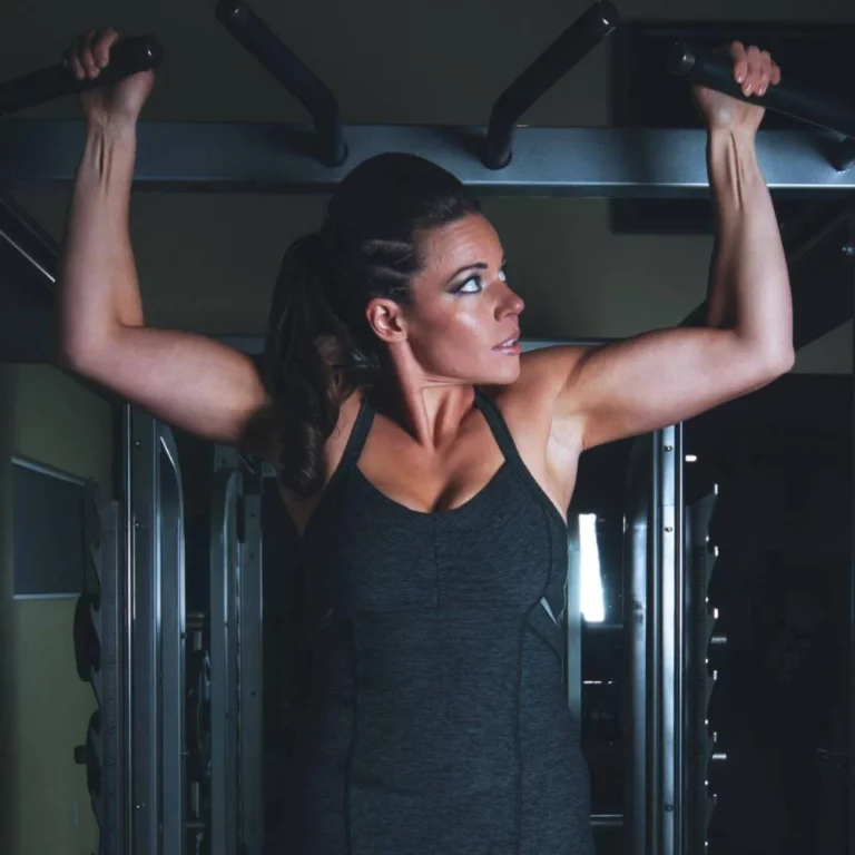 Fitness woman doing a wide grip pull-up